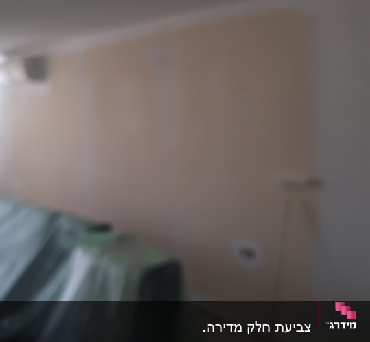 קיר צבוע חלקית עם רולר צביעה